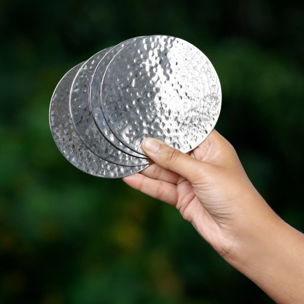 this is an image by the empty space that deals in premium home décor items online in India. The is an image of barware product of the empty spaces. The product is stainless steel metal hammered coaster which is made in India.